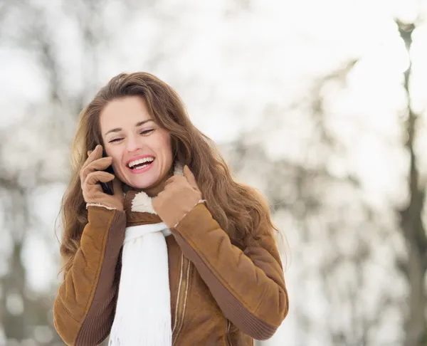 Porträtt av leende ung kvinna prata mobiltelefon i vinter p — Stockfoto