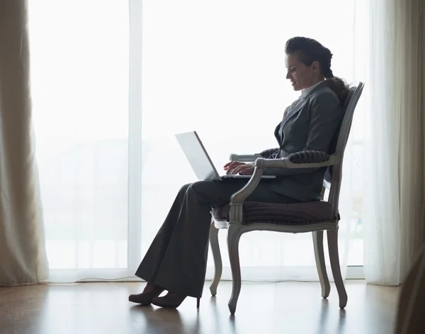 Silhouet van zakelijke vrouw die op laptop werkt — Stockfoto