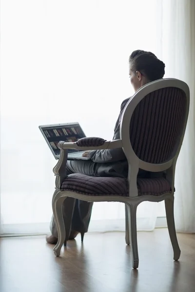 笔记本电脑工作的业务女人的剪影。后视图 — 图库照片