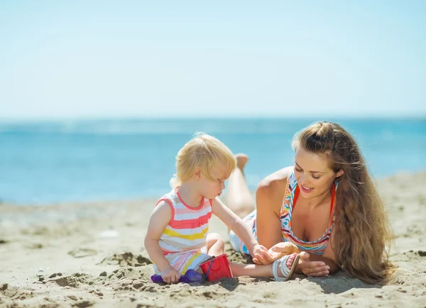 Madre y niña jugando con arena en la playa — Foto de Stock