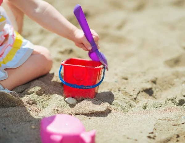 Kova ile oynayan bebek kız closeup ve kürek kumsalda — Stok fotoğraf