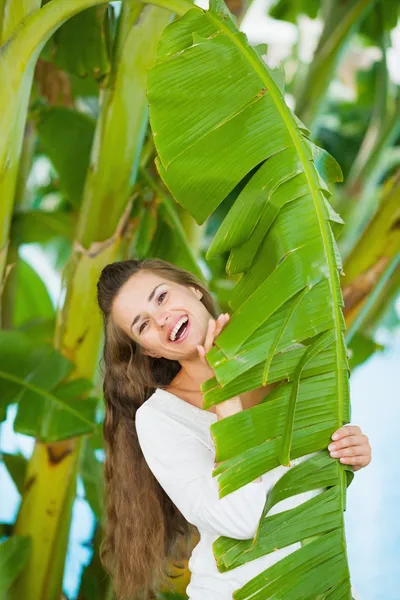 Porträt einer lächelnden jungen Frau inmitten tropischer Palmen — Stockfoto