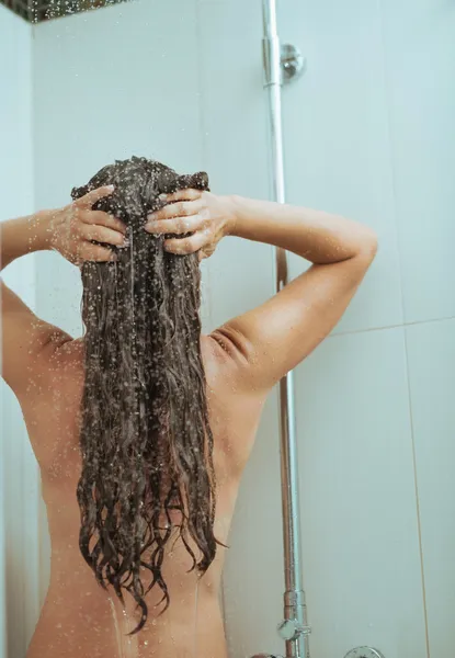 Jonge vrouw wassen in de badkamer. Achteraanzicht — Stockfoto