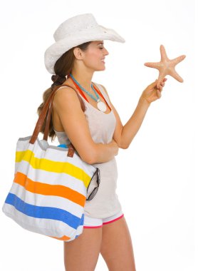 Deniz yıldızı tutan beach gülümseyen genç kadın