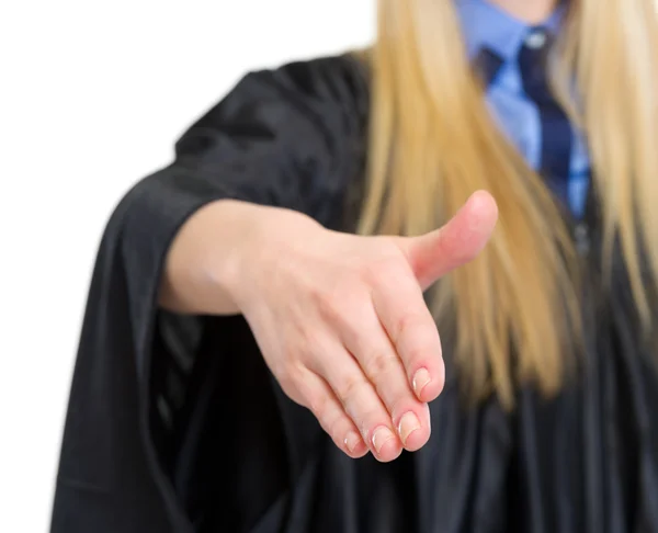 Close-up op vrouw in afstuderen toga uitrekken hand voor handshak — Stockfoto