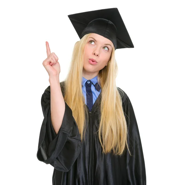 Feliz joven mujer en vestido de graduación tiene idea — Foto de Stock