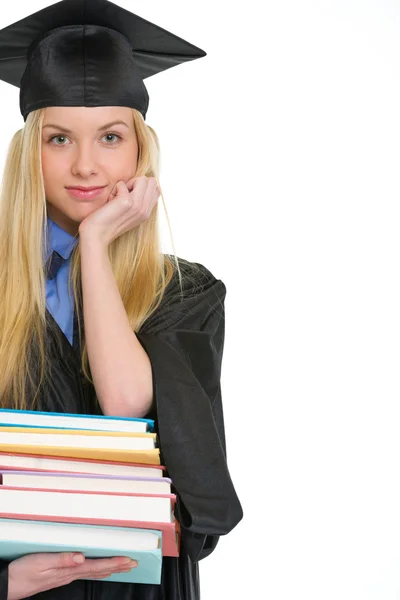 Jonge vrouw in afstuderen jurk met stapel boeken — Stockfoto