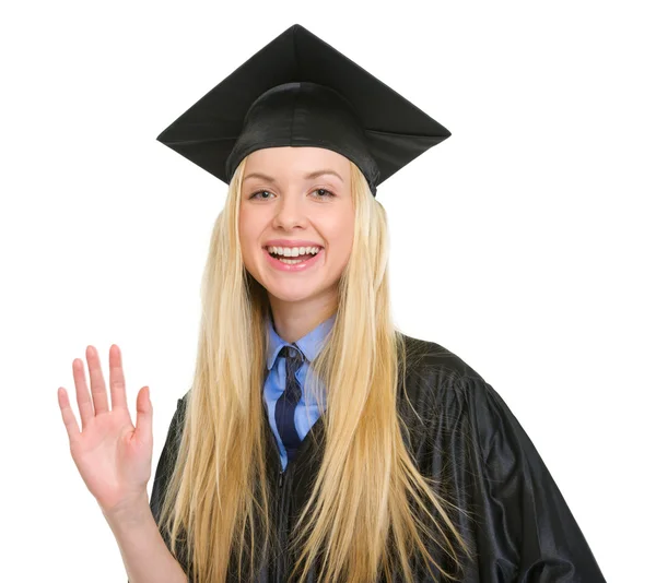 Gelukkig jonge vrouw in afstuderen gown groet — Stockfoto