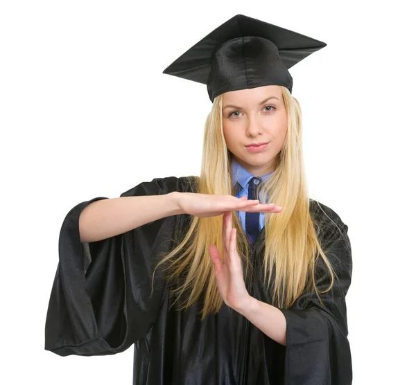 年轻女子在毕业礼服显示停止手势 — 图库照片