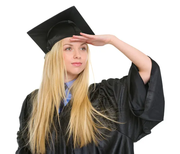 Jovem mulher em vestido de graduação olhando para a distância — Fotografia de Stock