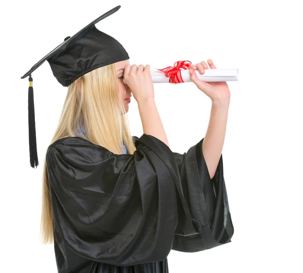 Young woman in graduation gown looking into distance through dip — Stock Photo, Image