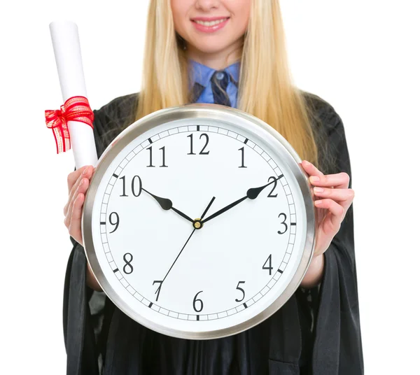 Zbliżenie na dyplom i zegar w ręce kobiety w studiach suknia — Zdjęcie stockowe