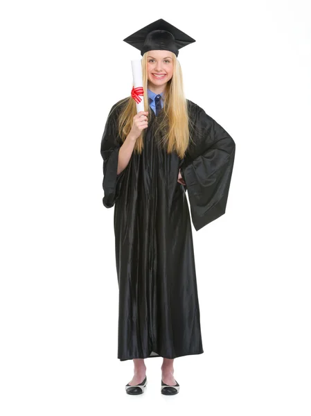 Retrato de comprimento total de jovem mulher em vestido de graduação mostrando d — Fotografia de Stock