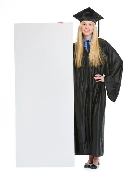 Full length portrait of smiling young woman in graduation gown s — Stock Photo, Image