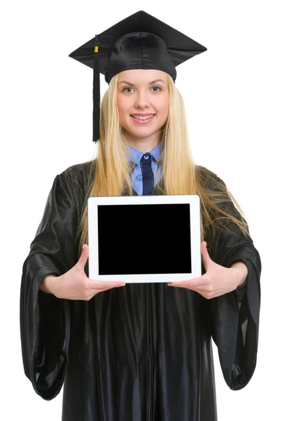 Sorrindo jovem mulher em vestido de graduação mostrando tablet pc — Fotografia de Stock