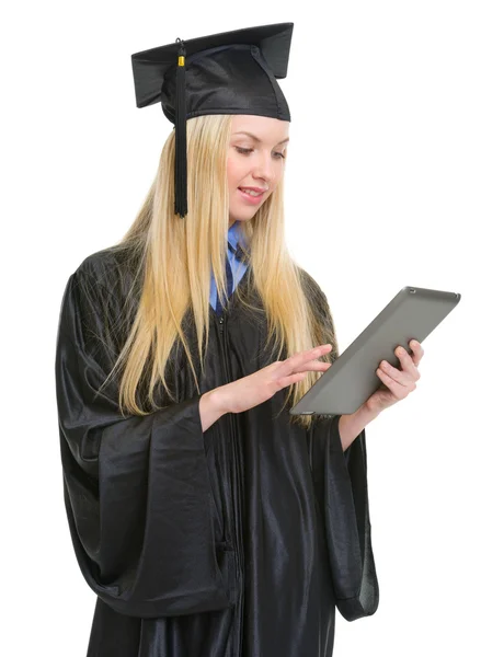 Gelukkig jonge vrouw in afstuderen jurk met behulp van tablet pc — Stockfoto