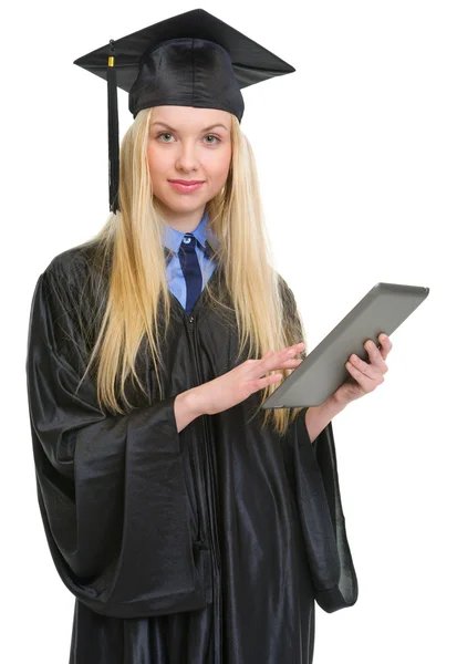 Jonge vrouw in afstuderen jurk met behulp van tablet pc — Stockfoto