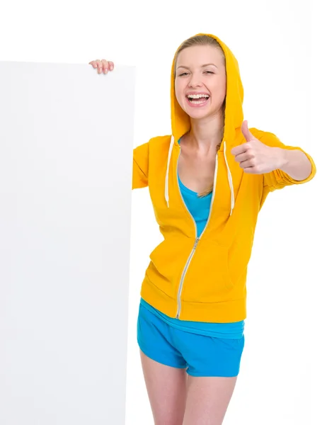 Sonriente adolescente chica mostrando cartelera en blanco y pulgares hacia arriba — Foto de Stock