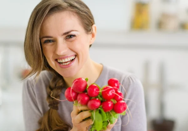 Portret van lachende jonge vrouw met bos van radijs — Stockfoto