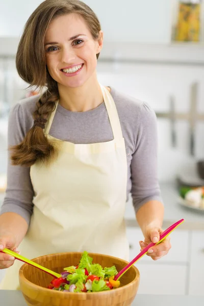 Jovem dona de casa feliz misturando salada fresca — Fotografia de Stock