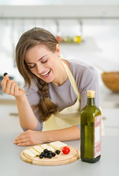 Gelukkig jonge vrouw eten van verse kaas en olijven — Stockfoto