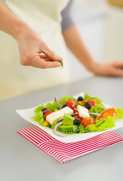 Close-up op vrouw toevoegen van verse dille in salade — Stockfoto