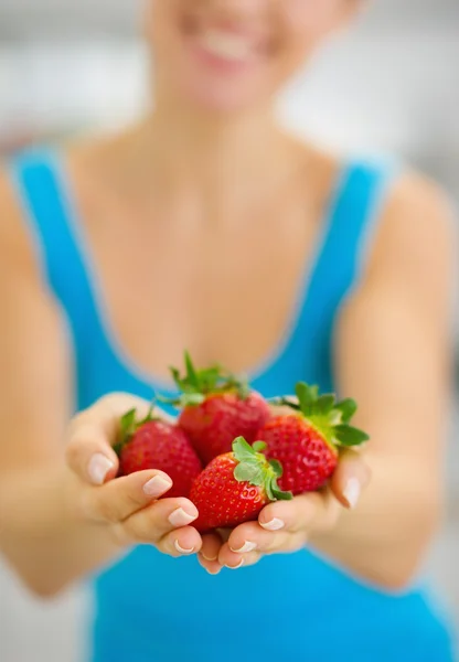 Gros plan sur une jeune femme souriante donnant des fraises — Photo