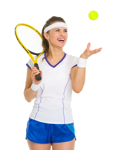 Lächelnde Tennisspielerin wirft Ball hoch — Stockfoto