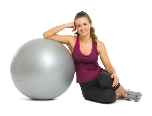 Happy fitness jovem mulher sentada perto de bola de fitness — Fotografia de Stock