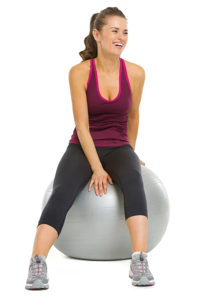 Souriant fitness jeune femme assise sur le ballon de fitness — Photo