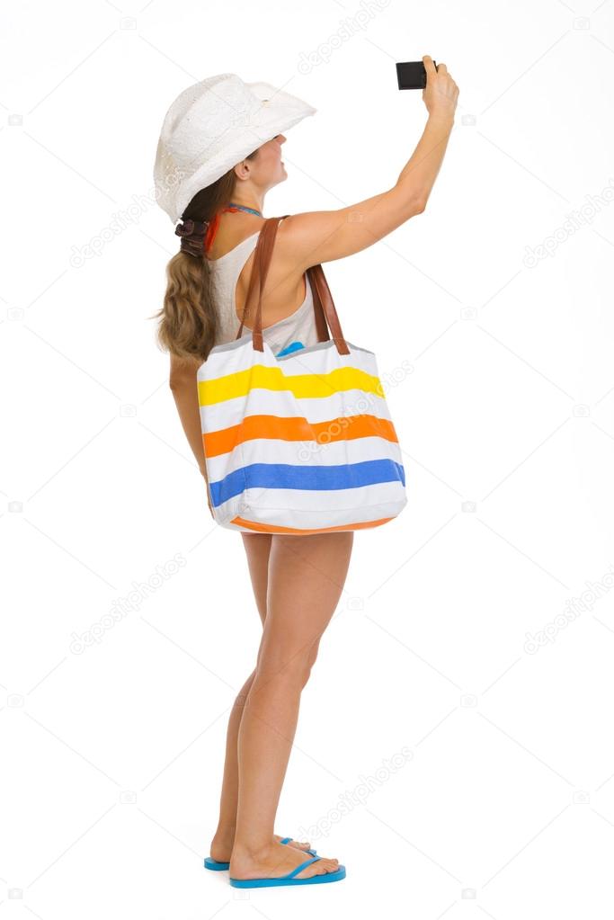 Full length portrait of beach young woman taking photo with came