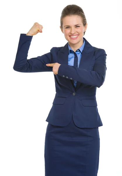 Mujer de negocios sonriente señalando bíceps — Foto de Stock