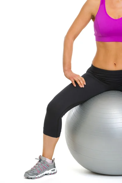 Closeup on slim young woman sitting on fitness ball — Stock Photo, Image