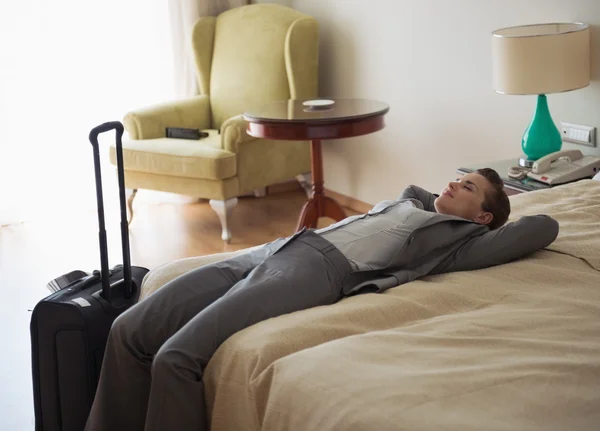 Mujer de negocios cansado acostado en la cama en la habitación de hotel —  Fotos de Stock