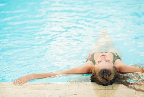 Mujer joven disfrutando de la piscina. visión trasera — Foto de Stock