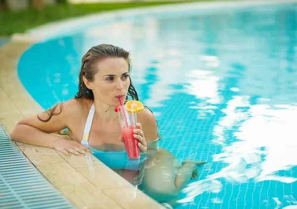 Giovane donna che beve cocktail in piscina — Foto Stock