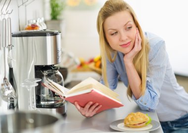 Mutfakta okuyan genç bir kadın