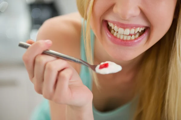 Primo piano su cucchiaio con yogurt in mano di ragazza adolescente sorridente — Foto Stock