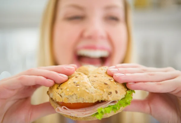 Närbild på burger i handen i leende tonåring flicka — Stockfoto