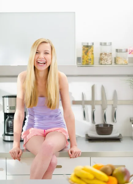 Портрет улыбающейся девочки-подростка, сидящей на современной кухне — стоковое фото