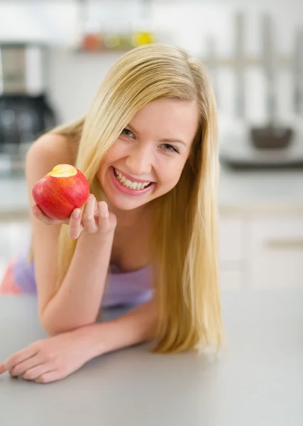 Menina adolescente feliz comendo maçã na cozinha — Fotografia de Stock