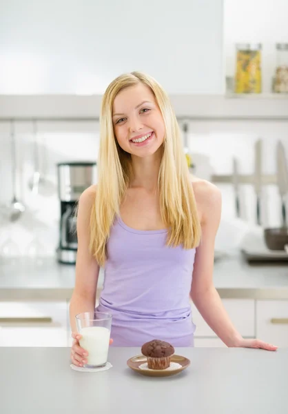 Gelukkig tiener meisje met glas melk en chocolade muffin — Stockfoto