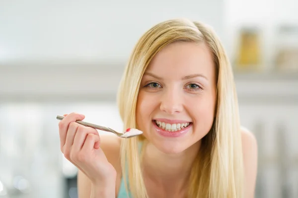 Smiling teenager girl with spoon of yogurt — Stock Photo, Image