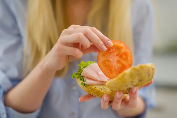 Primo piano sulla giovane donna che fa il sandwich in cucina — Foto Stock