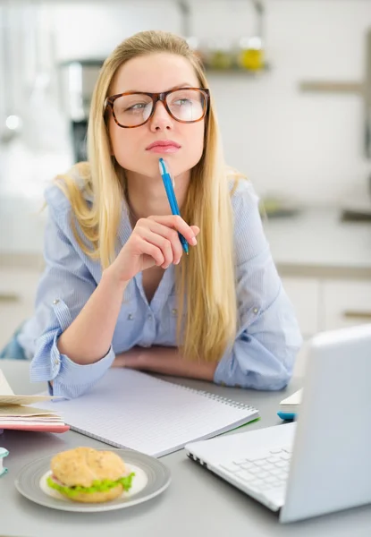 Menina adolescente pensativo estudando na cozinha — Fotografia de Stock