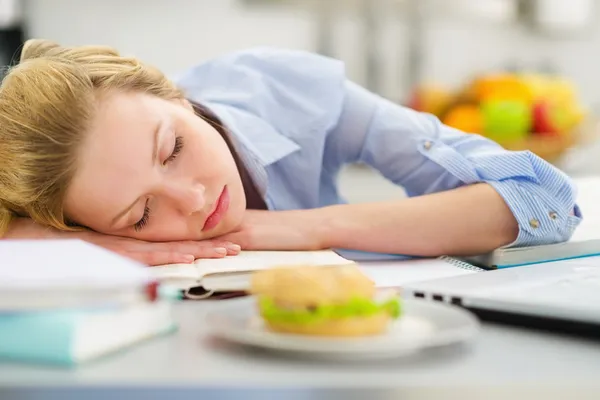 Teenage girl fall asleep while studying in kitchen — Stock Photo, Image