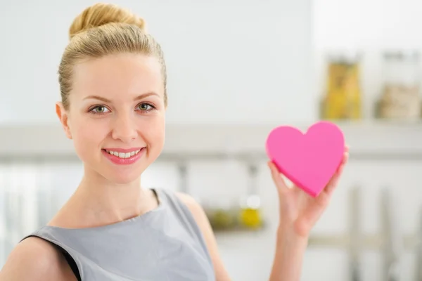 Portrait de jeune femme au foyer heureuse montrant coeur décoratif — Photo