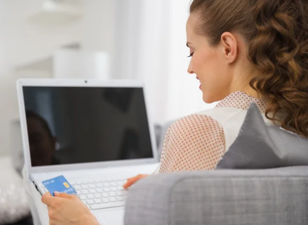 Happy young housewife with laptop and credit card — Stock Photo, Image