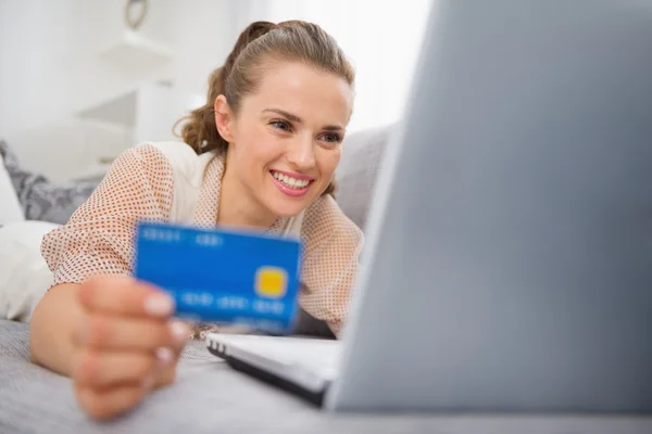 Boldog fiatal nő szóló divan laptop és hitelkártya — Stock Fotó