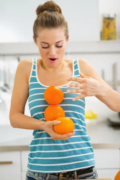 Junge Frau fängt fallende Orangen — Stockfoto